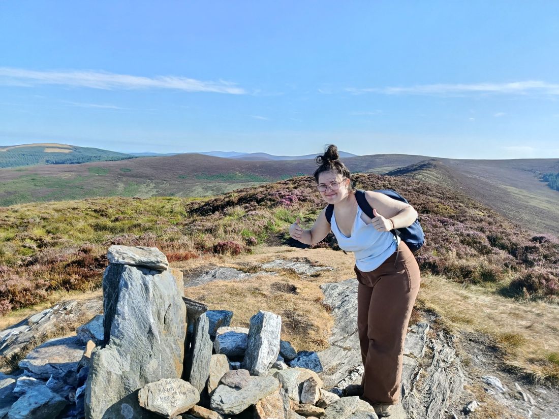 Ella giving a thumbs up on a hilltop