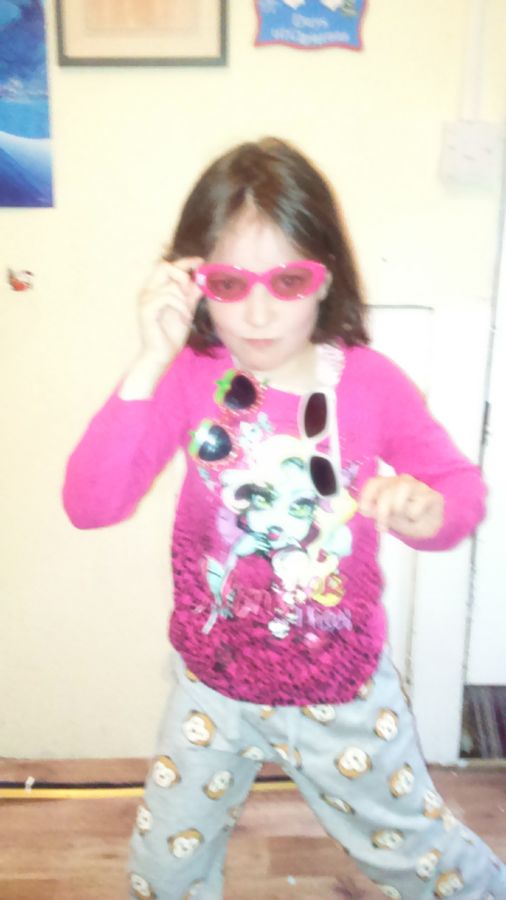 Young Ella posing in pink sunglasses