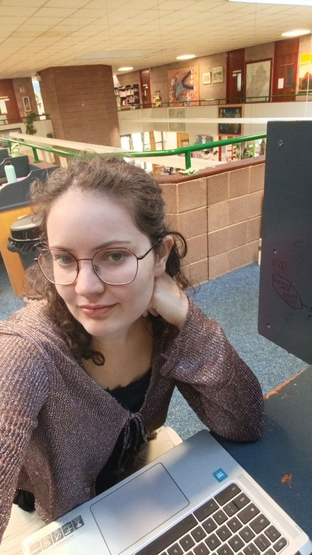 Ella at a laptop in a library