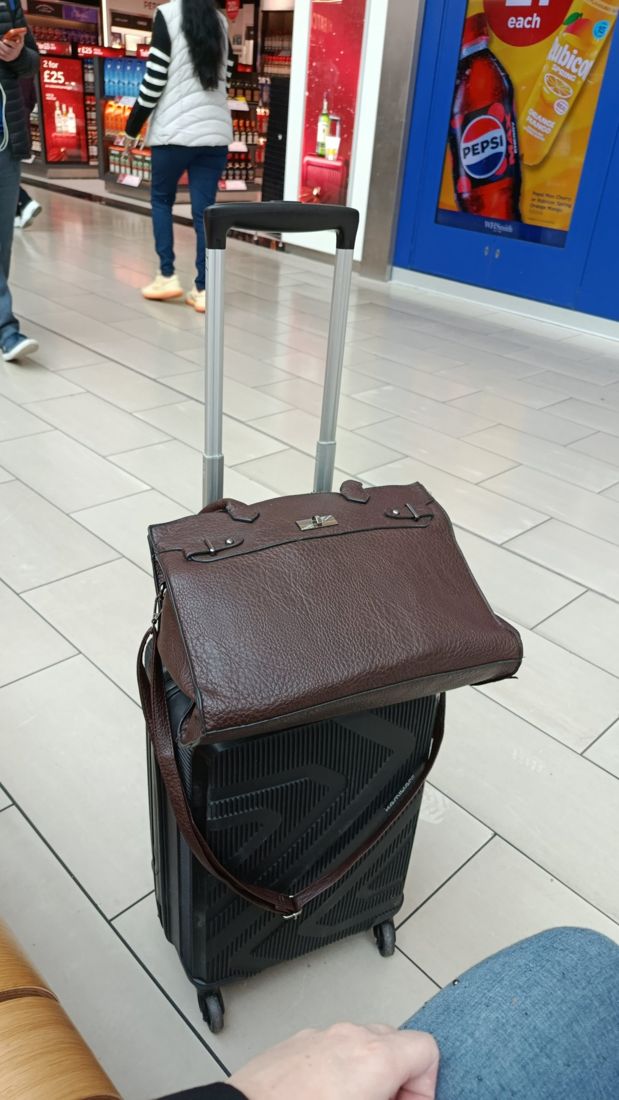 A suitcase and handbag at an airport